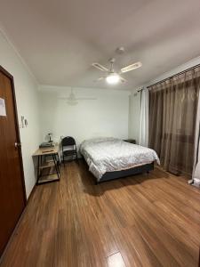a bedroom with a bed and a desk and a window at Guest Room in Kealba in St Albans