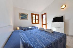 a bedroom with a blue bed and a tv at Bellavista in Funtana Meiga