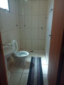 a bathroom with a toilet and a sink at Apartamento Laranja Matão in Matão +6 photos