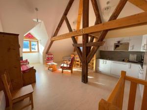 a kitchen and a living room with wooden beams at Alpes Montjoie in Faucon-de-Barcelonnette