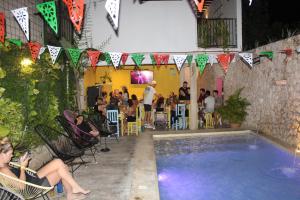 a group of people sitting in chairs around a swimming pool at VALLADOLID 48 Hotel & Hostal in Valladolid