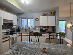 a kitchen with white cabinets and a granite counter top at Entire 2-bedroom, 2 bath home with parking and newly renovated floors in Canton