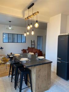 a kitchen with a table with chairs and a refrigerator at Chez Julie l Elégant en Centre-Ville in Castres +12 photos