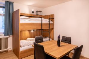 a dining room with a table and a bunk bed at Brauhaus-Hotel König von Flandern in Augsburg