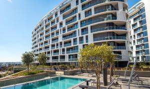 a large apartment building with a swimming pool in front of it at 2115 Kepler, Ellipse - Serene Luxury in Midrand