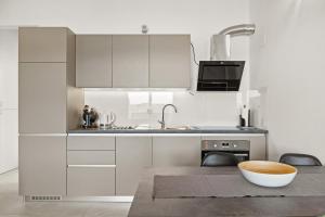 a kitchen with white cabinets and a bowl on a table at Apartments Jana & Paula in Cres