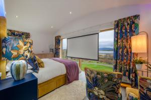 ein Schlafzimmer mit einem Bett und einem großen Fenster in der Unterkunft Ardtorna in Benderloch