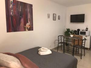 a bedroom with a bed and a table and a microwave at Studio Eros in Alençon