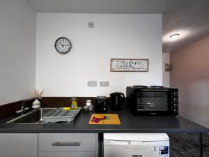 a kitchen counter with a microwave and a sink at BV Aparthotel Castleford Perfect for Cooperate and Leisure Stays in Castleford