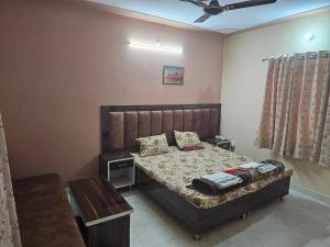 a bedroom with a bed and a table in it at The Ashok Vatika Farms and Stay in Haridwār +28 photos