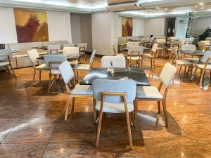 a dining room with tables and chairs in a room at Royal Center Hotel Lourdes in Belo Horizonte