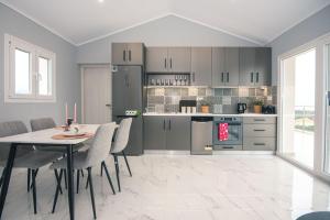 Una cocina con una mesa y sillas en una habitación. en Gigi Star Luxury ApartVilla with Pool, Panoramic Sea View, en Tsilivi
