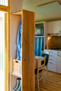 a small kitchen and dining room with a table in a tiny house at 408 Kleini-Haus mit Kamin und Strandkorb in Bleckede +19 photos