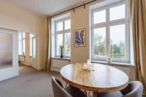 a dining room with a table and chairs and windows at Apartment mit Traveblick in Lübeck