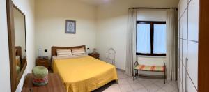 a bedroom with a yellow bed and a window at La Finestra sulla Valle in Secinaro