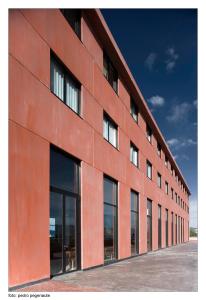een groot rood gebouw met glazen ramen bij Kyriad Direct ETH Rioja in Haro