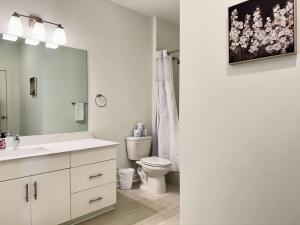 a bathroom with a toilet and a sink and a mirror at Luxury New 1B1B Private Balcony w Dryer Washer 525Pkwy in Atlanta