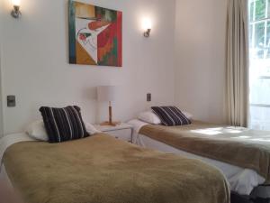 a room with two beds and a picture on the wall at Acogedora Casa para familias y grupos in Santiago