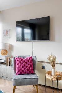 a living room with a purple pillow on a chair at Modern 1BR Woolwich Flat Elizabeth Line 5 Min in Woolwich