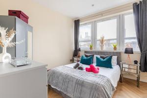 a bedroom with a bed with blue and red pillows at Modern 1BR Woolwich Flat Elizabeth Line 5 Min in Woolwich +15 photos