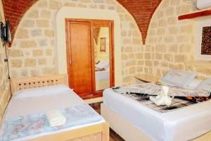 Qaryat at Ta‘mīr as SiyāḩīyahTebtunis Hotel的有两张床和一面镜子的房间