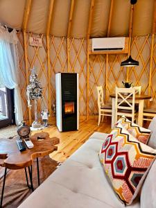 a living room with a couch and a stove in a yurt at Jurta na Wypasie - luksusowy namiot z widokiem na góry - Jacuzzi, Sauna, Split AC, Private, Star View in Zakopane