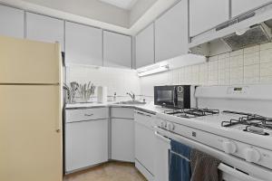 a white kitchen with a stove and a microwave at Your perfect stay - Cozy 2BR apartment in NOVA in Arlington +15 photos