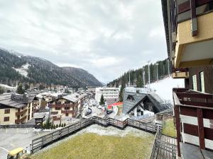 Vista aérea de un pueblo con una montaña cubierta de nieve. en Incantevole appartamento nelle Dolomiti, en Madonna di Campiglio
