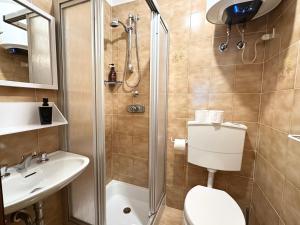 Un baño con ducha, inodoro y lavabo. en Incantevole appartamento nelle Dolomiti, en Madonna di Campiglio 20 fotos más