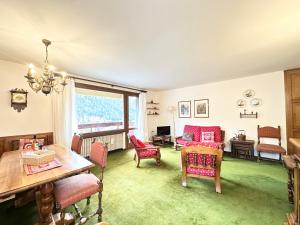 una sala de estar con una mesa y sillas en Incantevole appartamento nelle Dolomiti, en Madonna di Campiglio