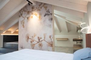 a bedroom with a wall with a painting of leaves at Pietralunga Resort in Fidenza +50 photos