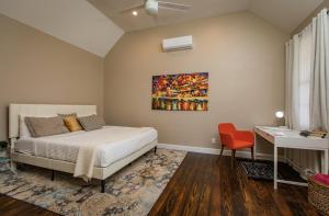 a bedroom with a bed and a desk and a painting on the wall at The Moko Jumbie House - Premier Suite in Christiansted