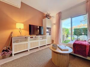 レスタルティットにあるLa Bella Lola Estartit Rentalのテレビと大きな窓のあるリビングルーム