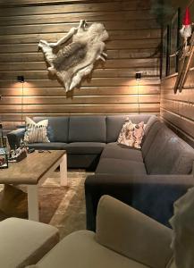 a living room with a blue couch and a table at ReindeerCabin PoroMökki LEVI in Kittilä +17 photos