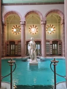 einen Brunnen in einem Gebäude mit einer Statue im Wasser in der Unterkunft Kurpark Apartment, Schwimmbad, Sauna, Terrasse in Bad Wildbad