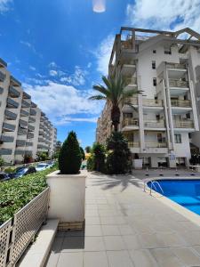 an apartment complex with a swimming pool and palm trees at L'Eixideta in Salou