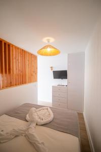 Un dormitorio con una cama con una toalla encima. en Wave Shadows Beach House Oceanfront property - Bottom Floor, en Paul do Mar