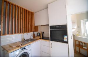 a kitchen with a washing machine and a sink at Wave Shadows Beach House Oceanfront property - Bottom Floor in Paul do Mar +9 photos