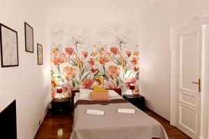 Una habitación con una cama y una pared floral. en Cozy Old Town Apartments, en Cracovia