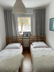 two twin beds in a bedroom with a window at FeWo Oberwiesenthal in Kurort Oberwiesenthal
