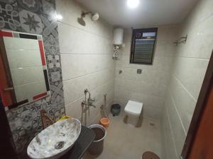 un bagno con lavandino e WC di Green Valley Resort Villa ad Alibaug Altre 15 foto