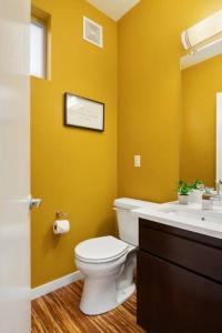 bagno giallo con servizi igienici e lavandino di Stylish 3 BR Capitol Hill Home With 96 Walk Score a Seattle Altre 15 foto
