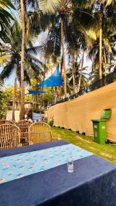 una mesa azul con sillas, una valla y palmeras en Garden Aroma Palolem, Beachside Hostel & Cafe Bar, en Palolem