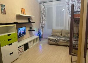a small living room with a couch and a television at gemütlich eingerichtetes Familienhaus in Montricher