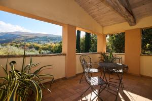 porche con sillas, mesas y vistas en Scappo in Umbria, villa Claudia, en Foligno
