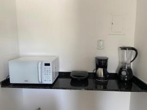 a kitchen counter with a microwave and a blender at Ap sossegado na Praia do Canto in Vitória