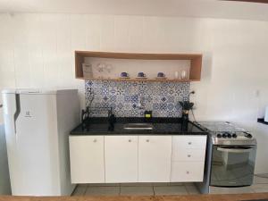 a small kitchen with a sink and a refrigerator at Ap sossegado na Praia do Canto in Vitória