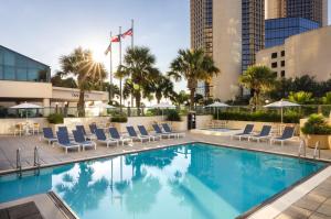 Una piscina con tumbonas y un edificio. en Omni Corpus Christi Hotel, en Corpus Christi