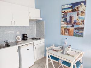 a small kitchen with a table and a sink at Seafront Studios and Apartments in Chios