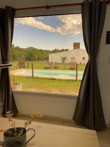 a window with a view of a pool at AROMA DEL POTRERO in Potrero de los Funes